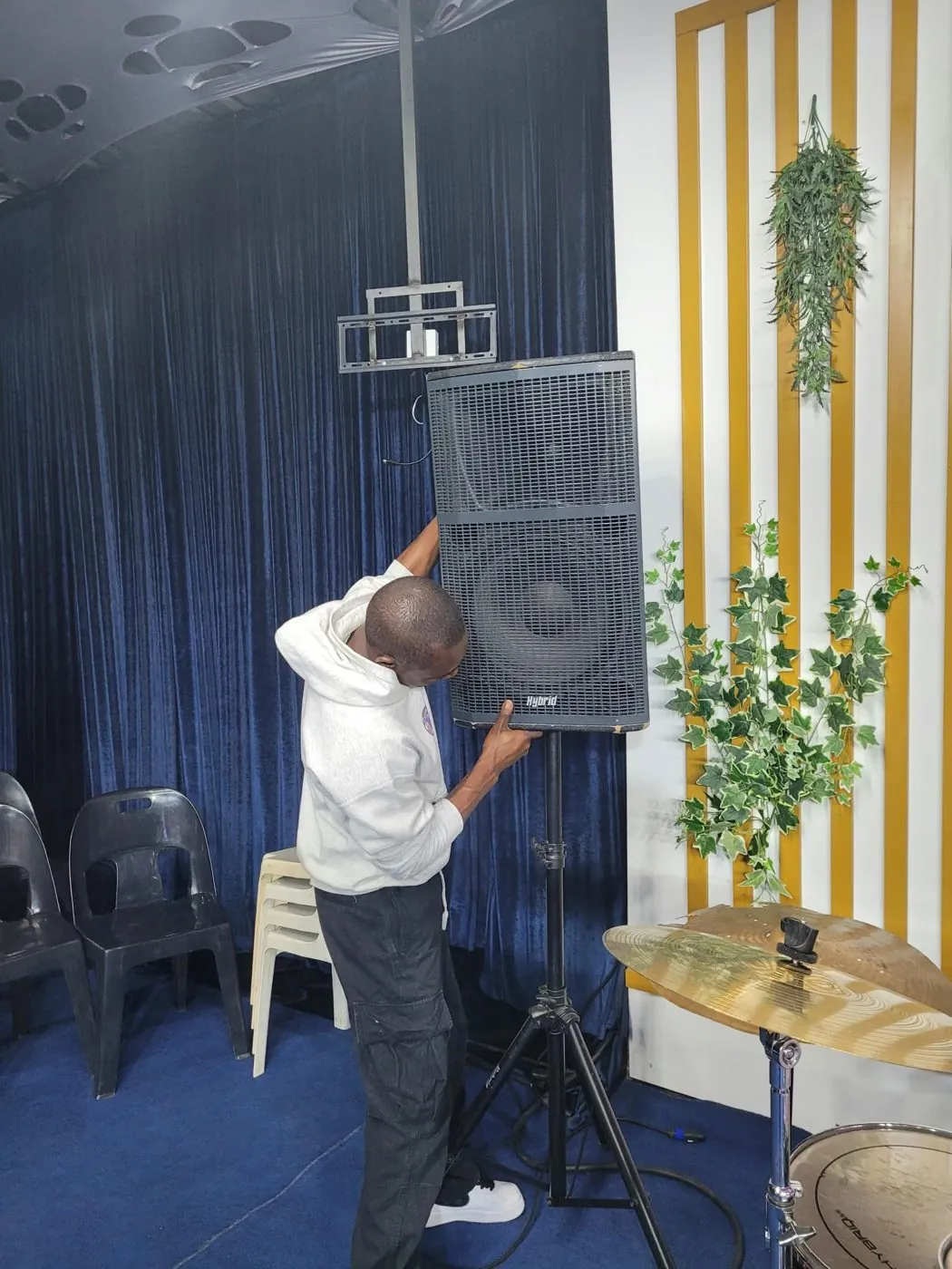 Alpha on stage holding a coil of cable at a live event venue